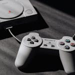 Retro Sony PlayStation console with classic controller, evoking nostalgic gaming memories.